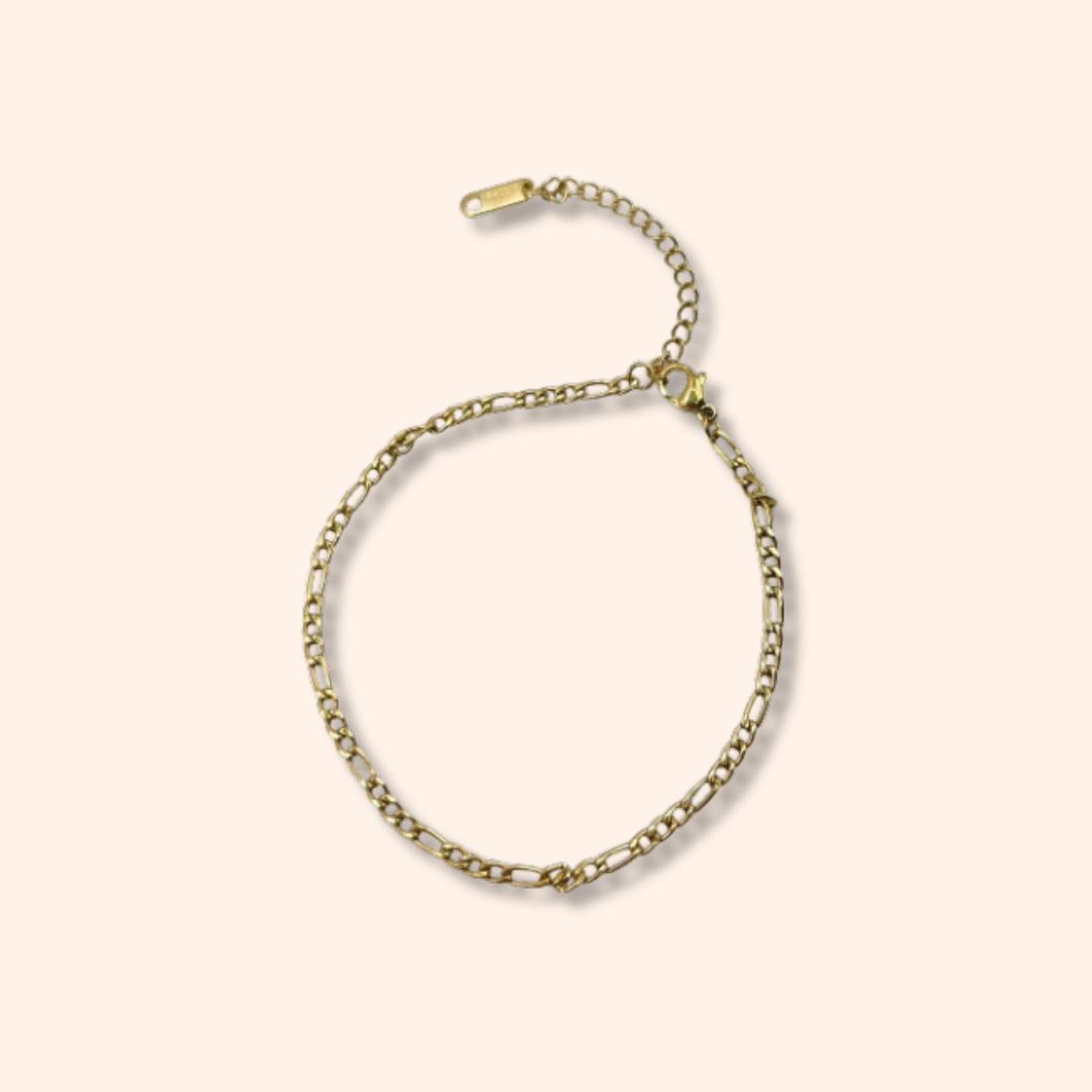Gold chain bracelet on a beige background