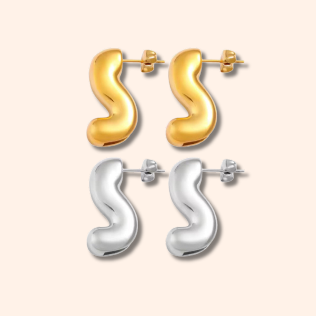 Pair of gold and silver 'S' shaped earrings on a white background
