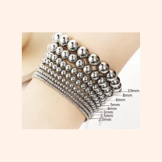Silver beaded bracelet on a wrist with size measurement chart