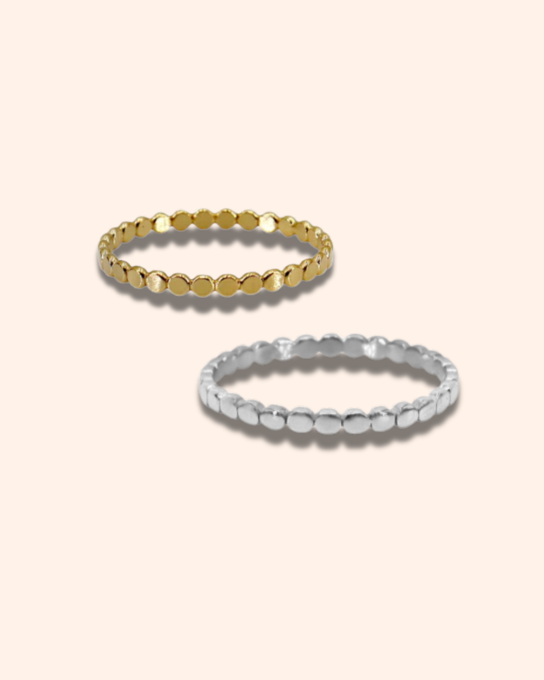 Two gold and silver beaded rings on a beige background