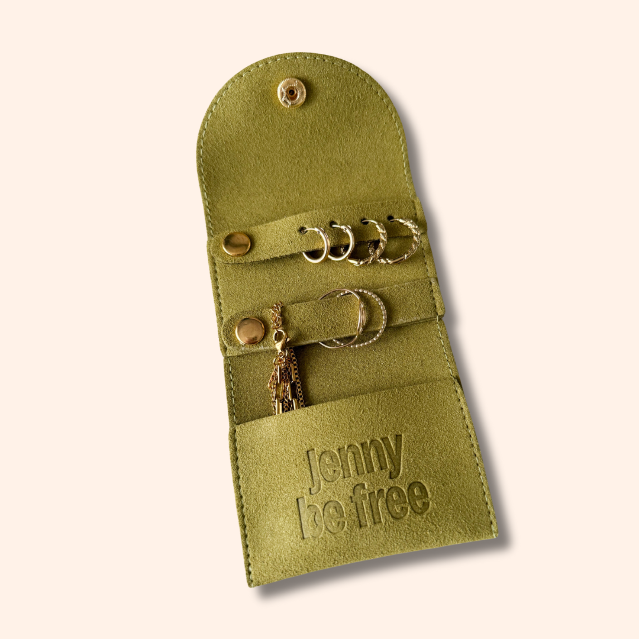 Green jewelry roll with 'jenny be free' branding on a white background