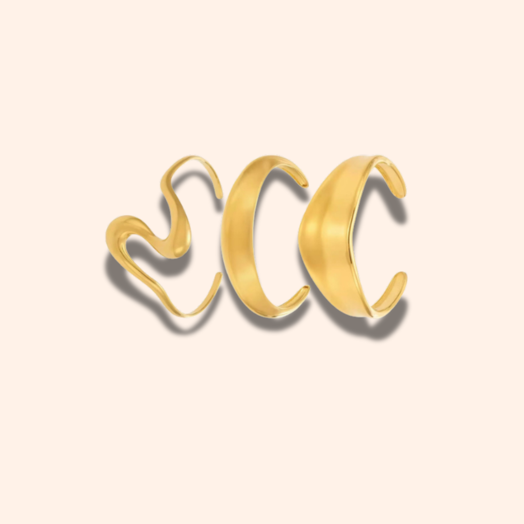 Gold open cuff bracelet on a beige background