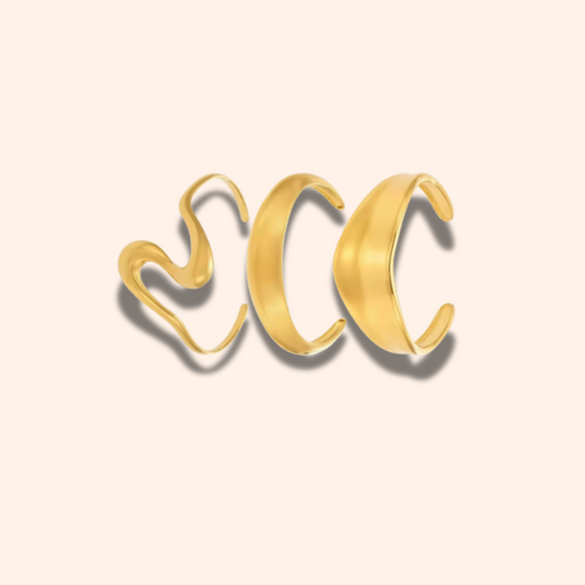 Gold open cuff bracelet on a beige background