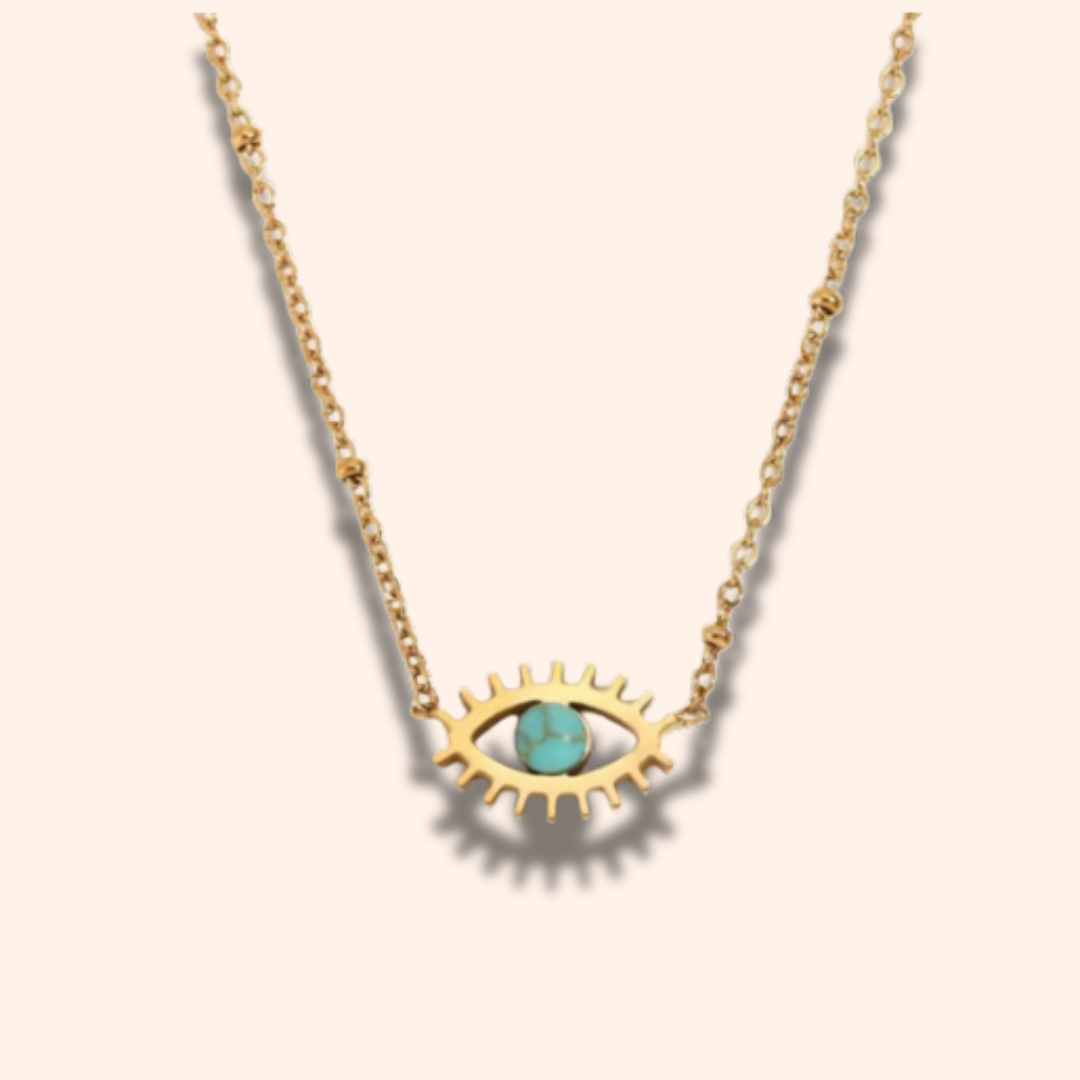 Gold necklace with eye-shaped pendant and turquoise stone on a beige background
