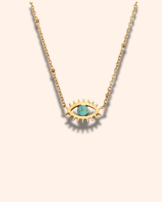Gold necklace with eye-shaped pendant and turquoise stone on a beige background