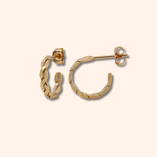 Gold hoop earrings on a beige background