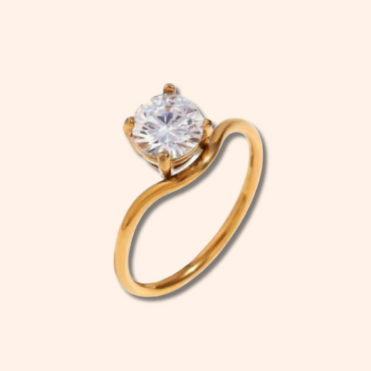 Gold ring with a large diamond on a beige background