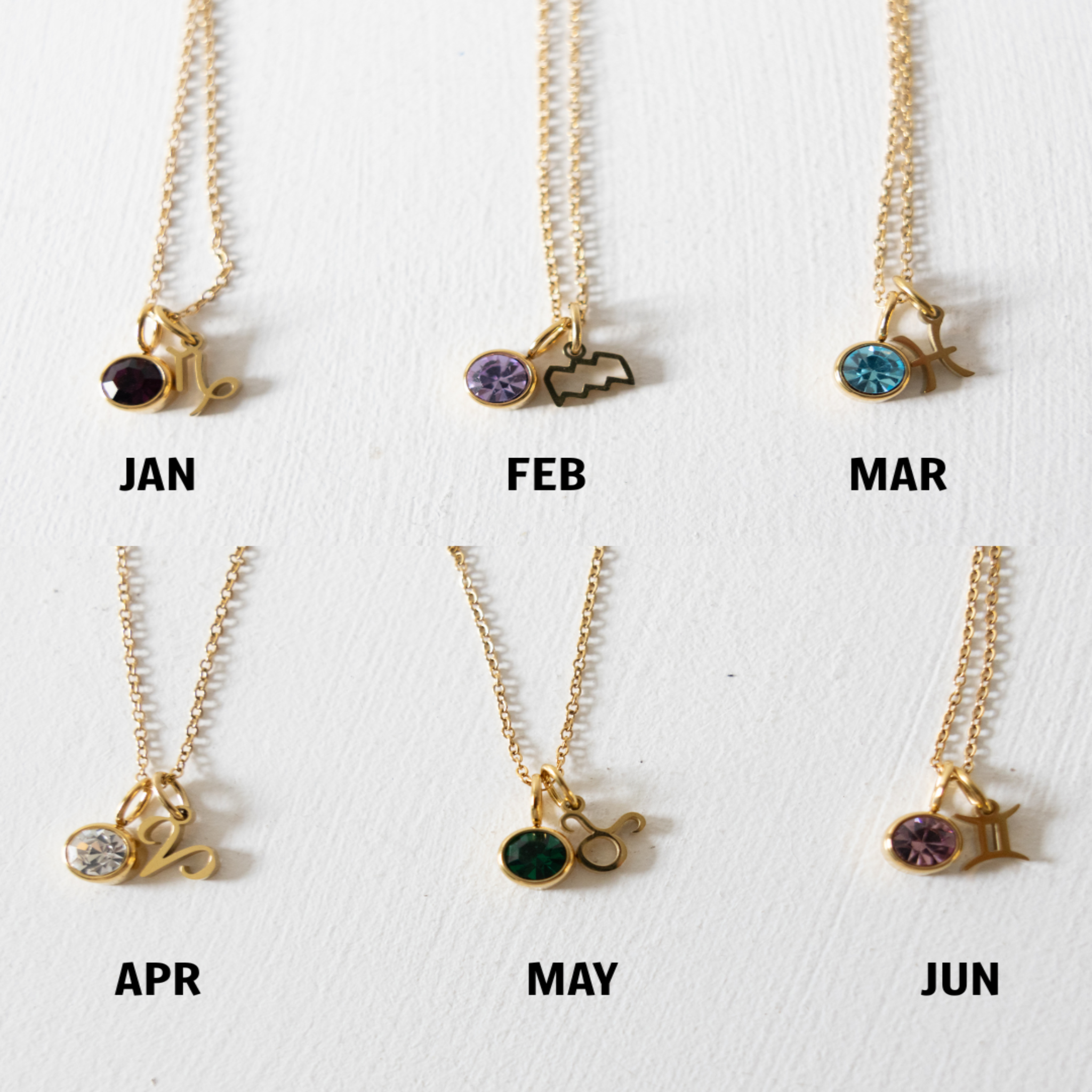 Set of six gold necklaces with zodiac symbols and birthstones on a white background