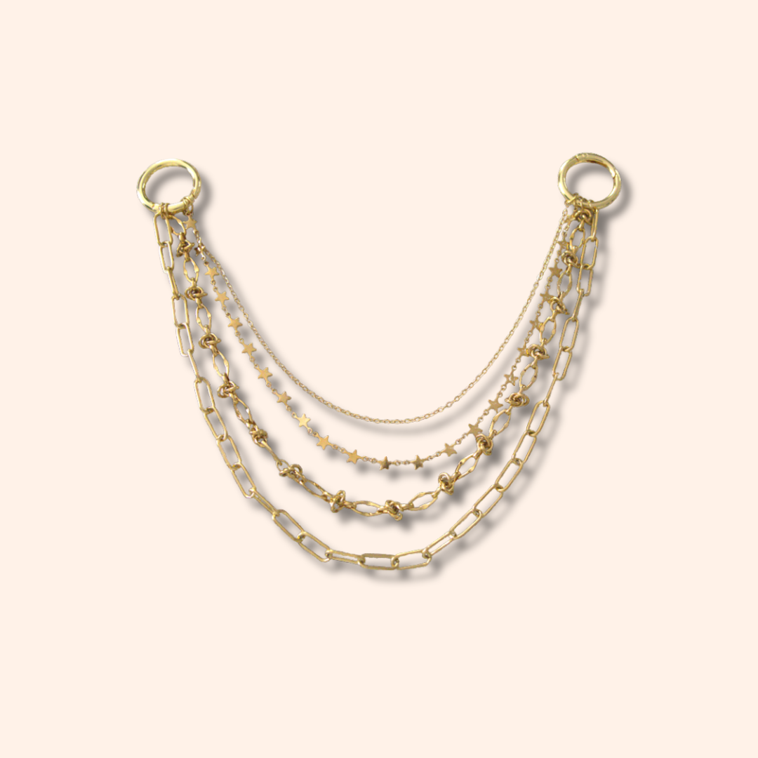 Set of three gold necklaces on a beige background