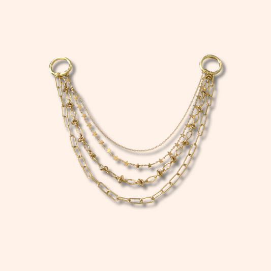 Set of three gold necklaces on a beige background