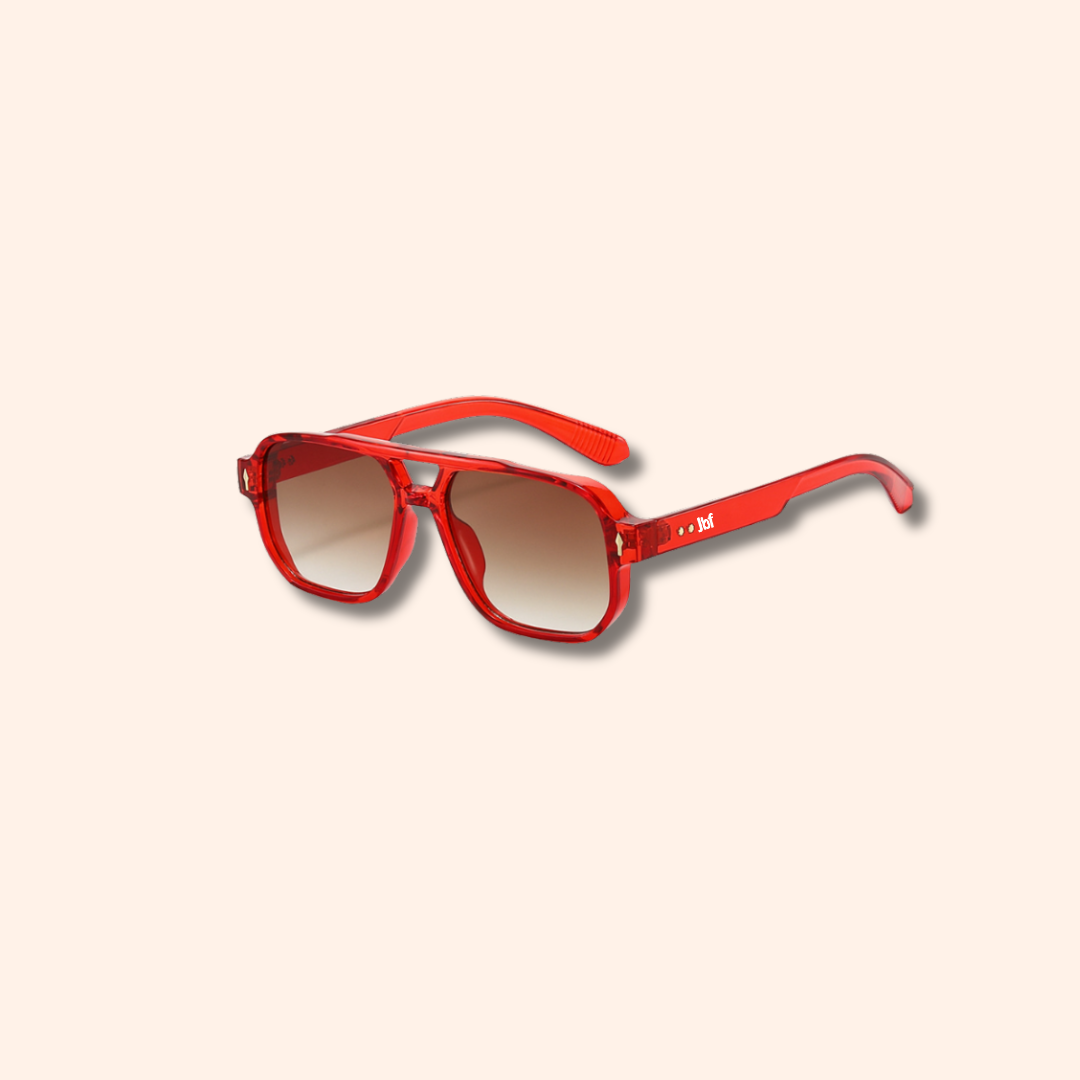 Red sunglasses with a gradient lens on a light beige background