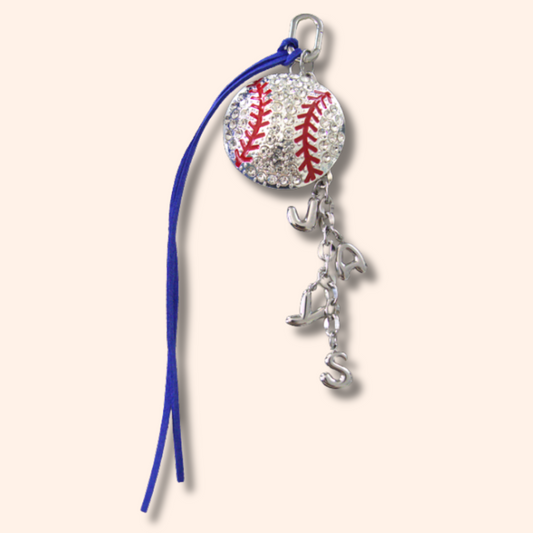 Baseball charm with blue string on a white background