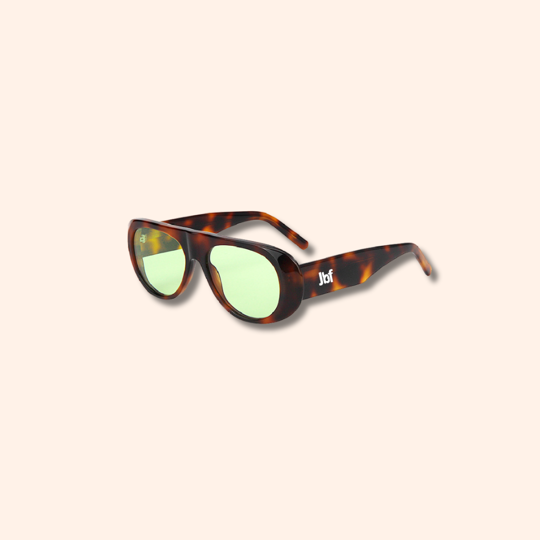 Sunglasses with tortoiseshell frame and green lenses on a white background