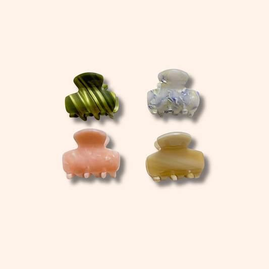 Four colorful hair clips on a beige background