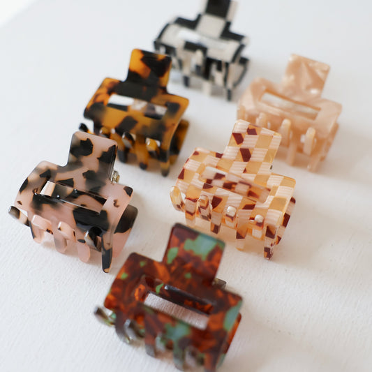 Set of six tortoiseshell and patterned hair clips on a white background